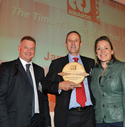 Timber Trader of the Year: Peter Latham, from winning company James Latham plc, receives the Timber Trader of the Year award from Neil Forbes, of sponsor Weinig, and Sarah Beeny